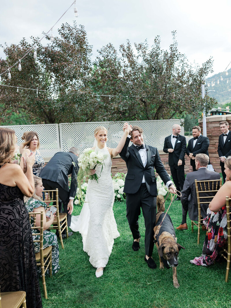 Bride and groom walk down the aisle with their dog at their elegant black-tie wedding at St. Julien Hotel in Boulder, Colorado.