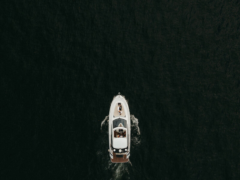 Elopement photographer captures a top-down view of a couple on a moving boat