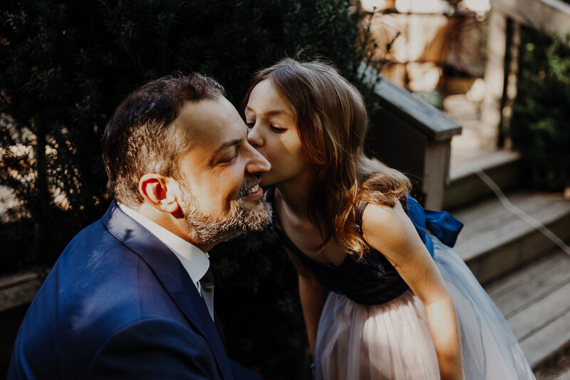 daughter kissing father on the cheek
