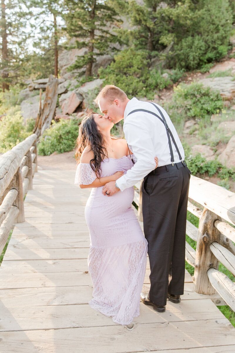 maternity session wife and husband kiss at Lily Lake, RMNP, Colorado