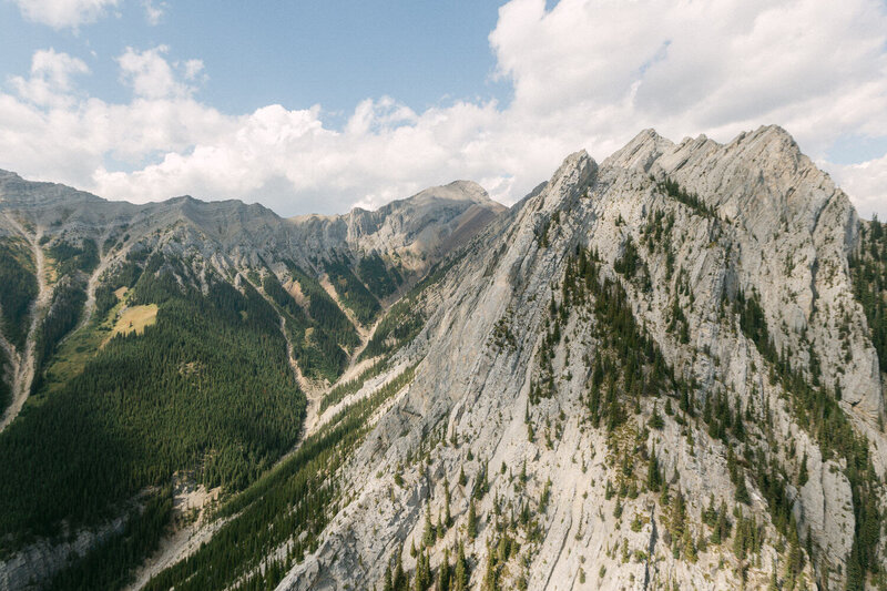 View from the helicopter overlooking vast mountains in the Canadian Rockies, showcasing the rugged landscape.