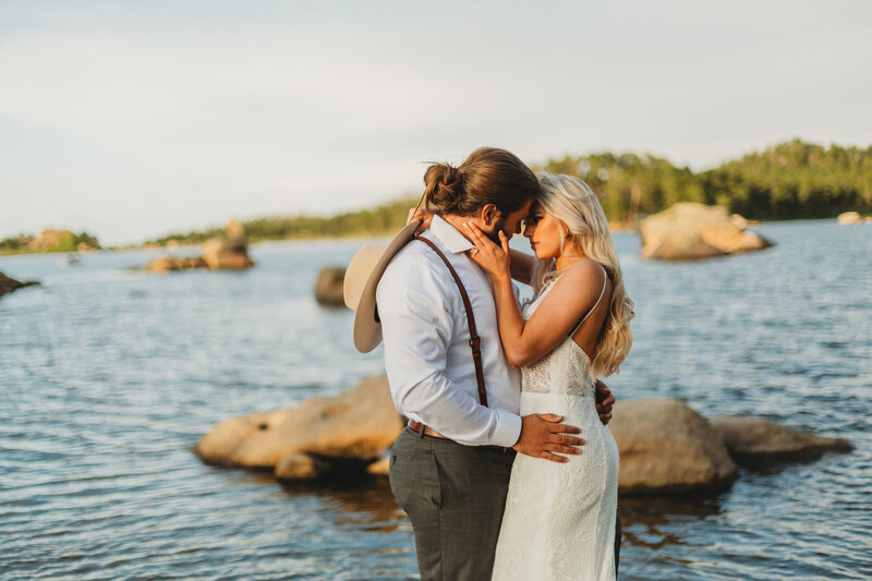 During their intimate elopement in Red Feather Lakes, Colorado, a bride and groom share a tender embrace, surrounded by the serene beauty of the forest.