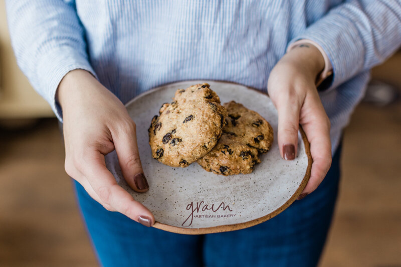 Person holding a plate of freshly baked gluten-free cookies at Grain Artisan Bakery in Snohomish, Washington, representing the bakery’s commitment to community and craft.