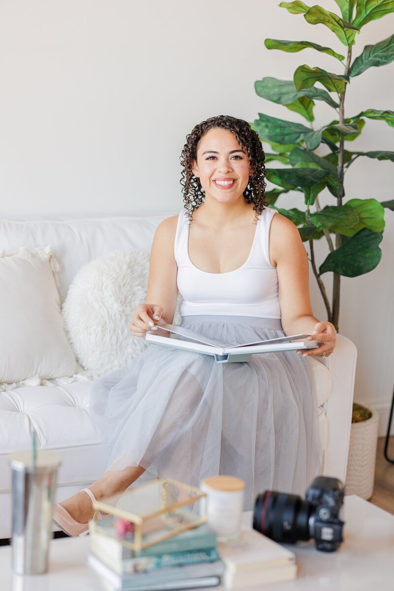 A woman holds a wedding album to answer why do you need a printed wedding album? 