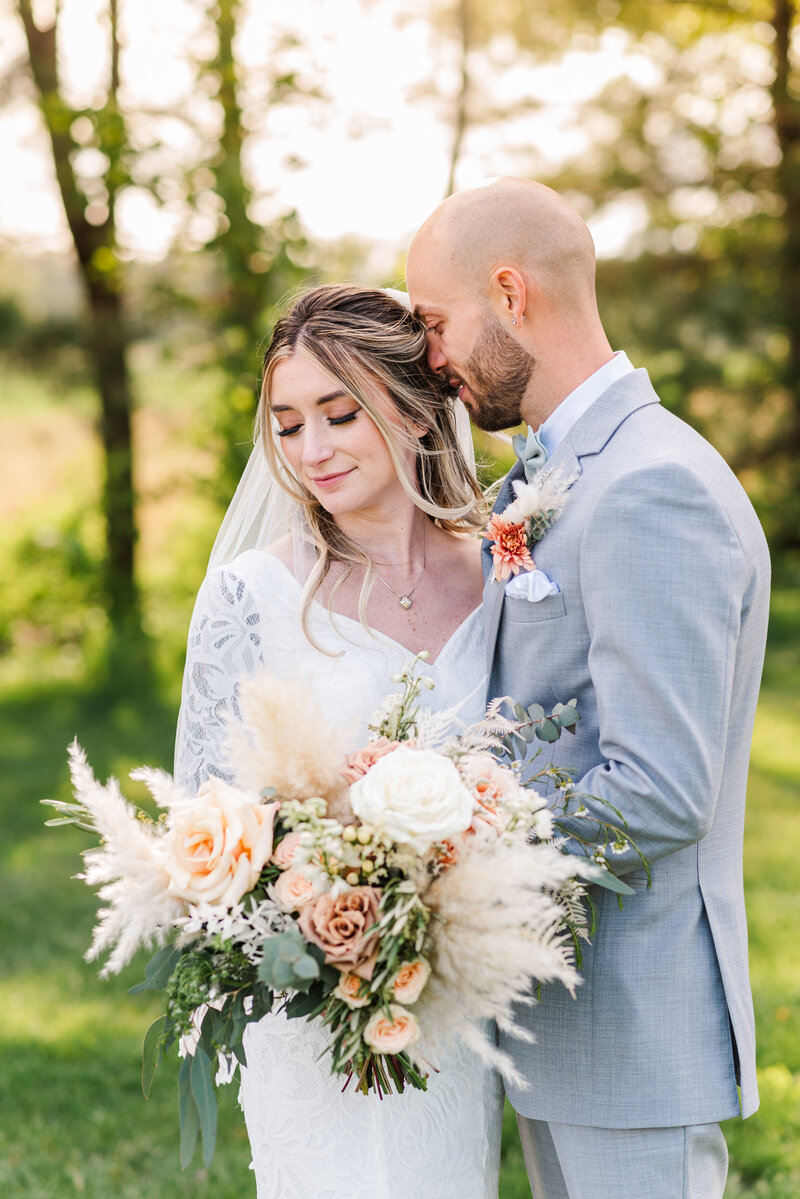 A bride and groom standing together steering a boat.