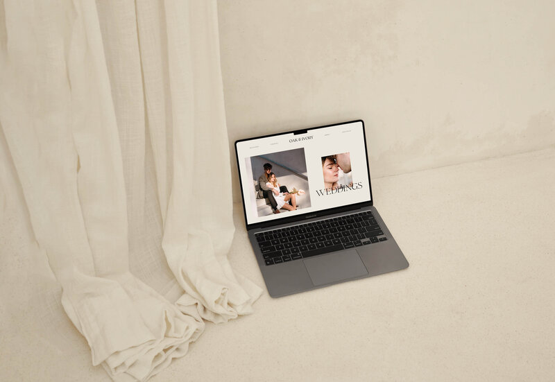 Laptop on a concrete floor shows elegant wedding photographer website