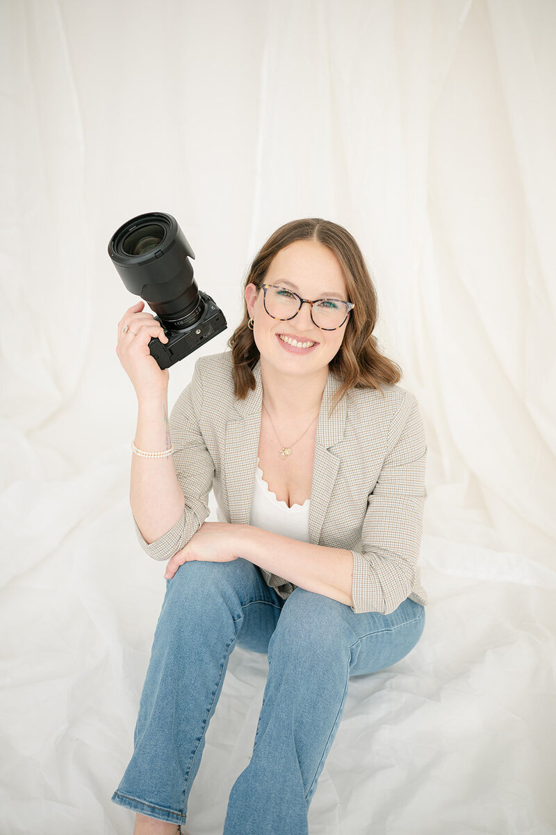 Margit smiling and holding her camera in her right hand