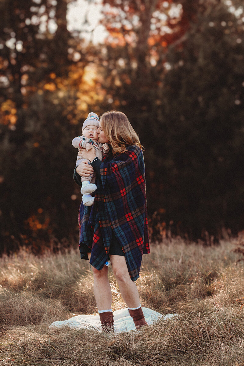 Mom and baby boy sharing kisses during a holiday mini session.