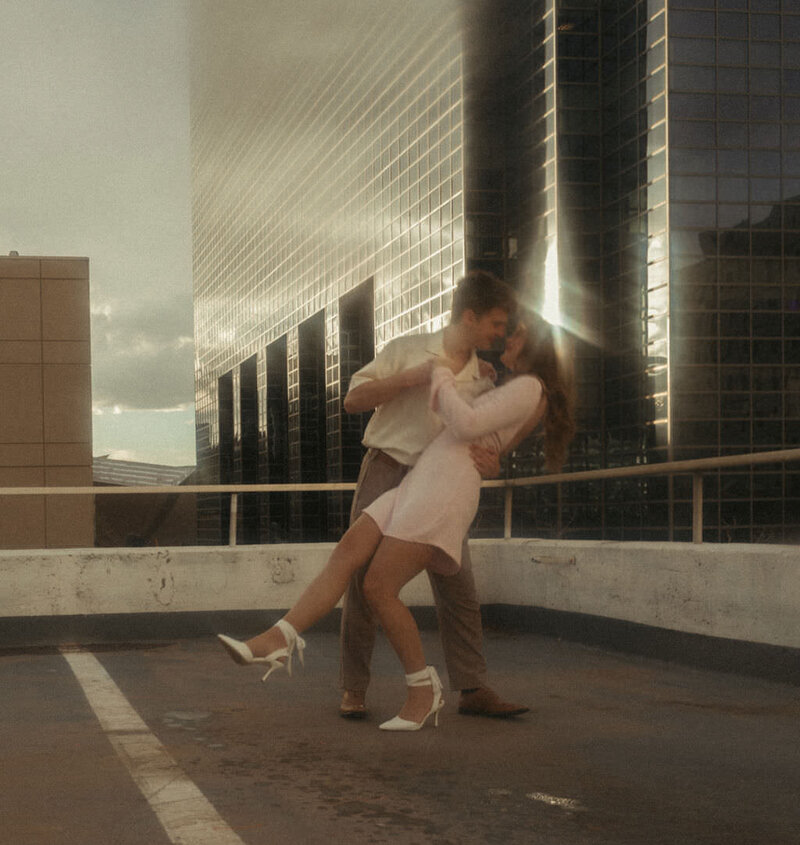 A couple dancing on the roof of a parking garage.