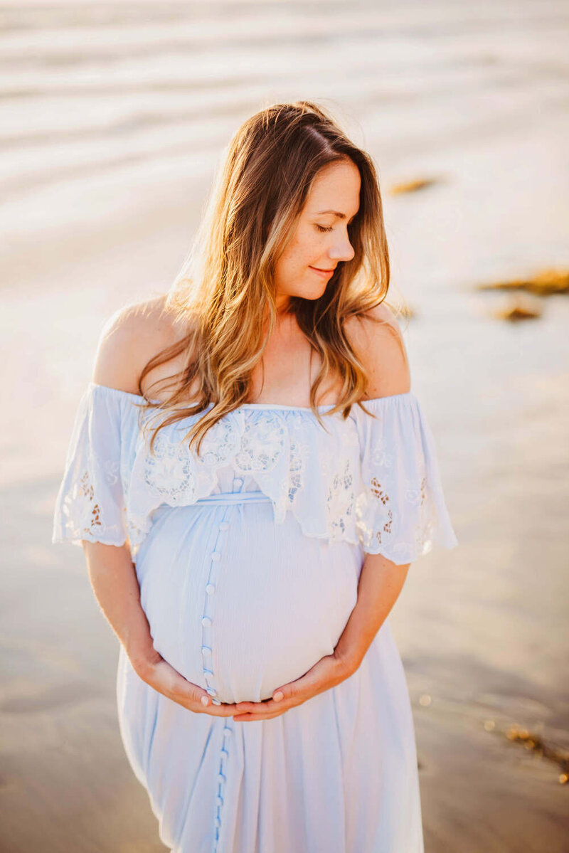 Beautiful maternity client being photographed on the beach