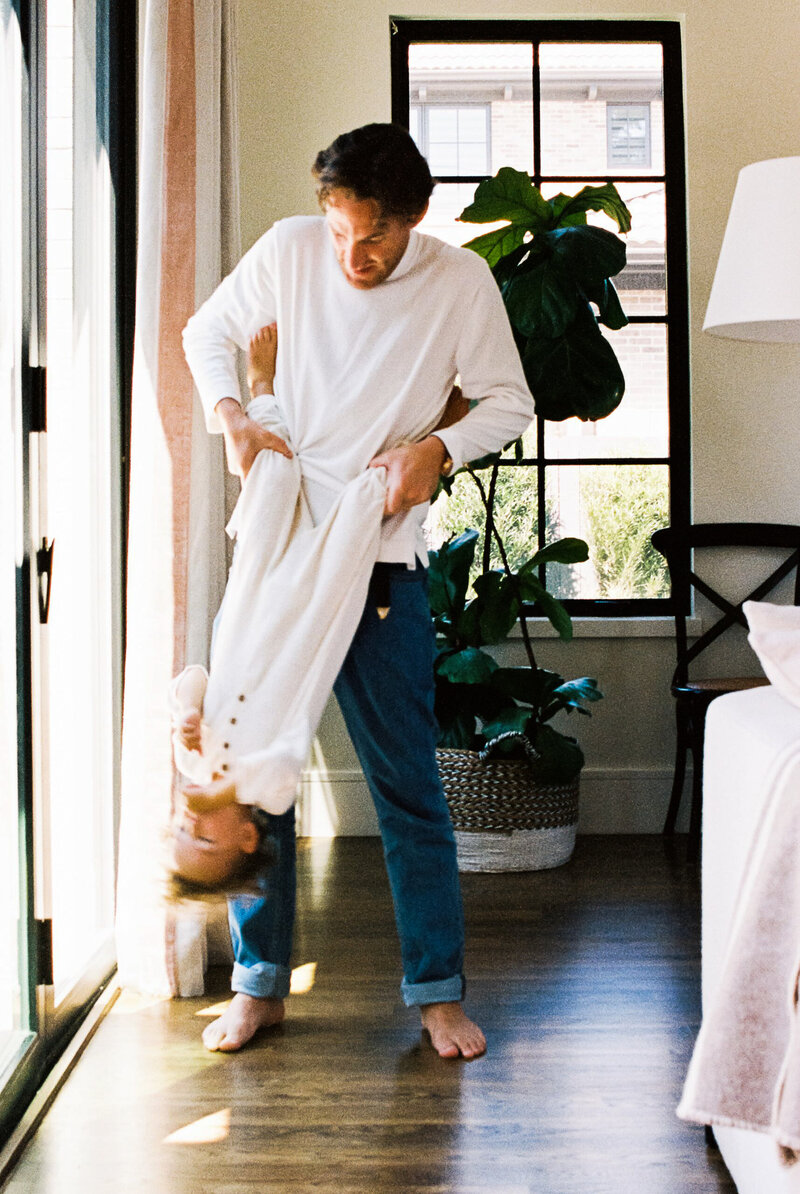 In-home professional family photography session featuring dad playing with toddler boy
