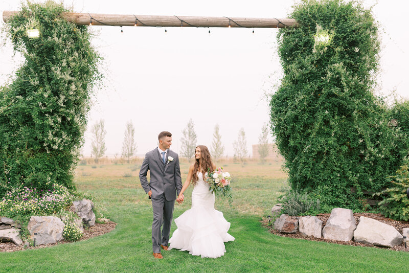 Bride and groom in front of barn trellis