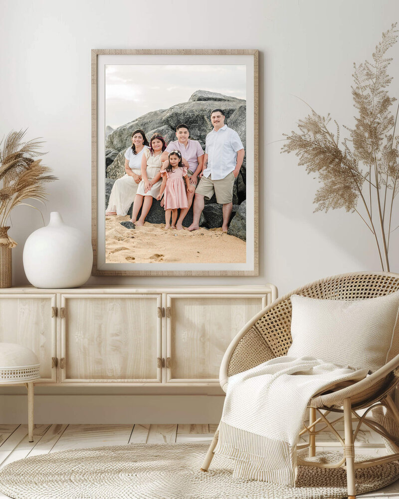 A photo of a family at the beach hangs above a table near a saucer chair. The family is dressed in neutrals and pinks to match their neutral decor.