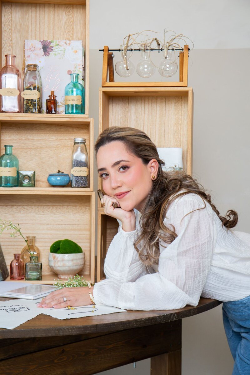 Merlyn Asencio standing confidently at her table, exuding professionalism and expertise as a trauma therapist committed to supporting clients in Miami, Florida