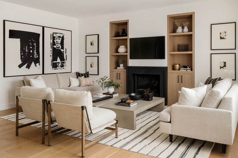Living room with black plaster fireplace, white oak built ins and abstract artwork. 