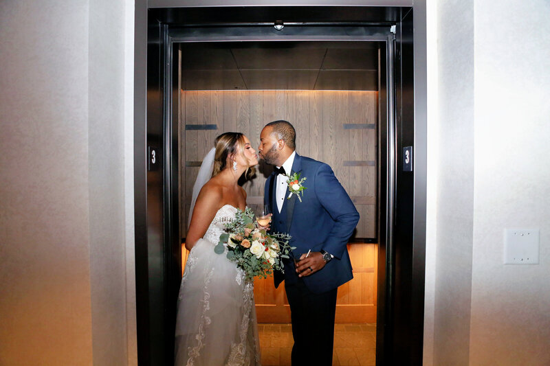 Bride and groom lean in for a kiss inside elevator of 1 Hotel Nashville