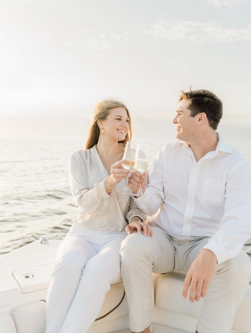 engaged couple toasting on a boat