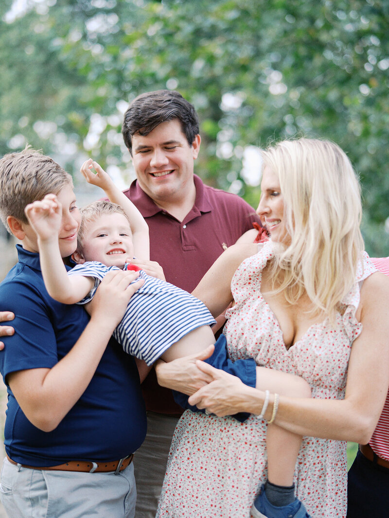 A family holding and playing with a child at a Richmond family photography session by Katie Stansfield Photography.