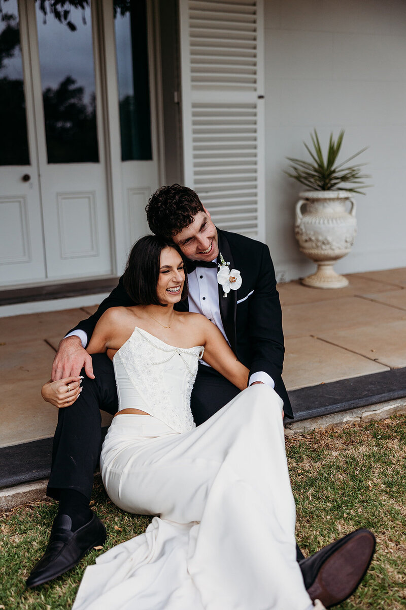 Bride and Groom portrait sitting on grass steps at Somerley House in Sutton Forest NSW. Photo by Acacia and Grace Photography | Canberra Wedding Photographer