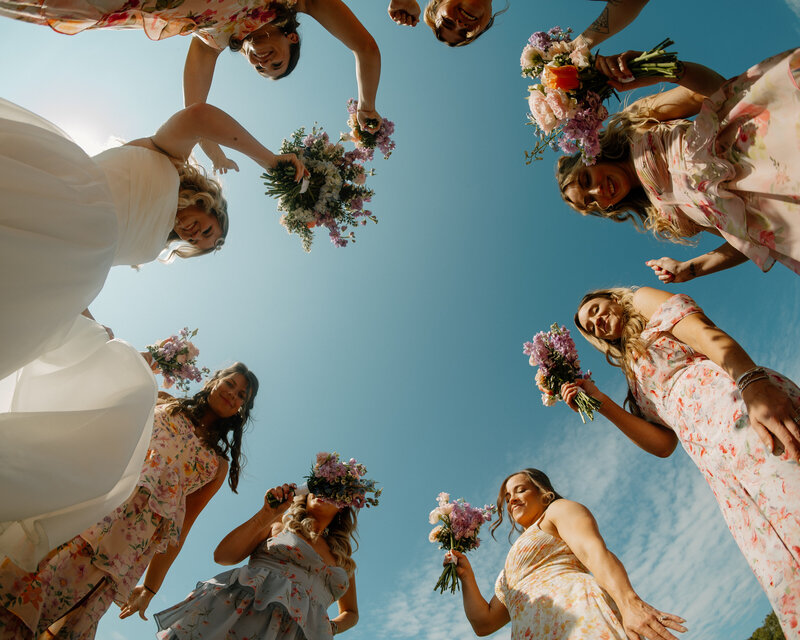 A couple dances in a golden field at sunset, with one person twirling the other while smiling, capturing a moment of joy.
