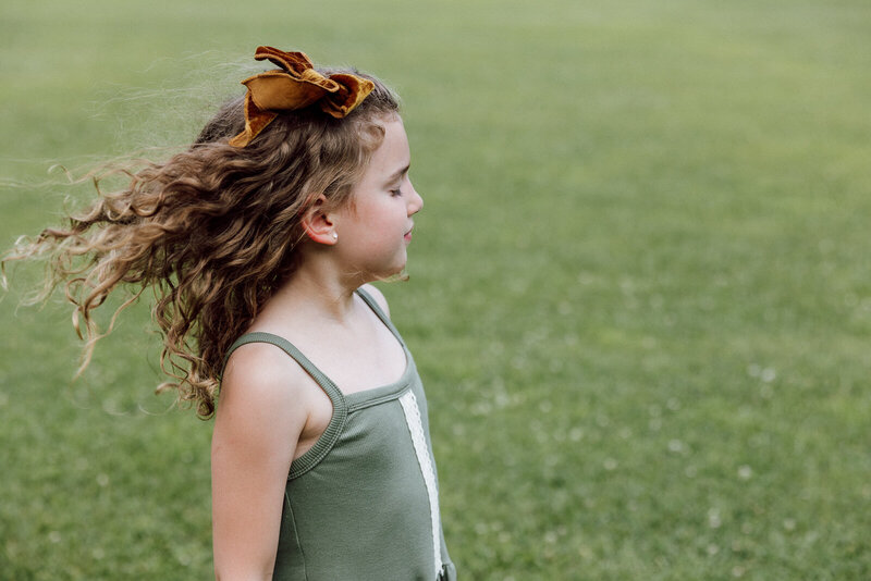 Portrait of a girl facing the wind while her hair blows behind her. 