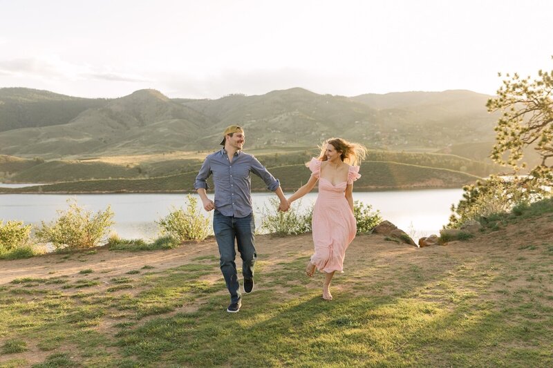 Engagement session at Horsetooth Reservoir in Fort Collins with couple running together at sunset | Northern Colorado engagement photographer