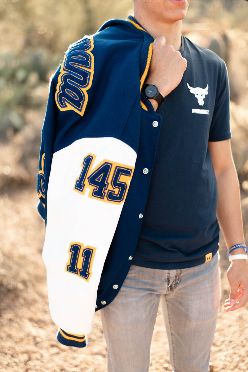 Senior putting lettermans jackets hanging over shoulder.