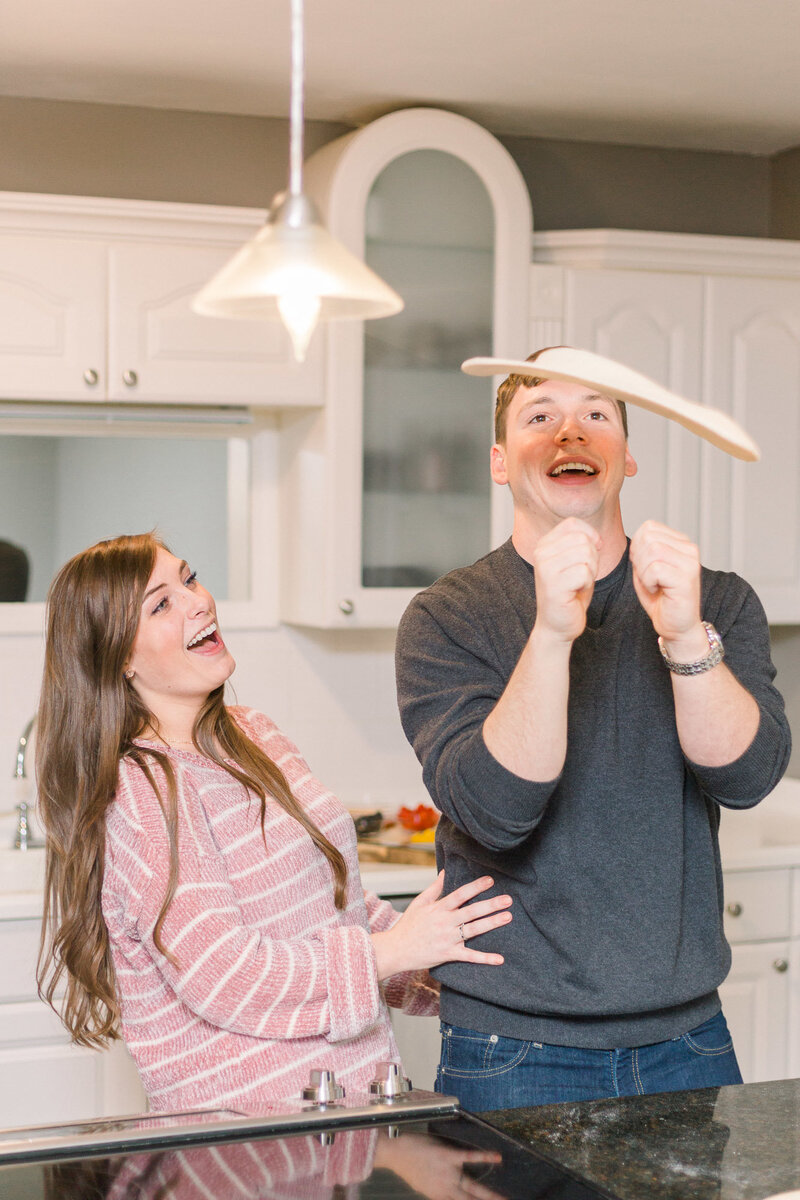 Couple spinning pizza dough