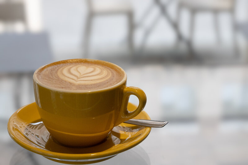 Cappuccino in yellow mug with spoon