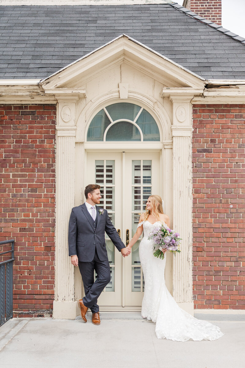 Wedding portraits at Magnolia Hotel balcony in Omaha, NE by Claire Katan.