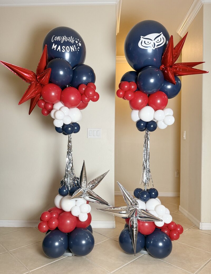 Graduation balloon tower in navy, red, and white with silver starbursts
