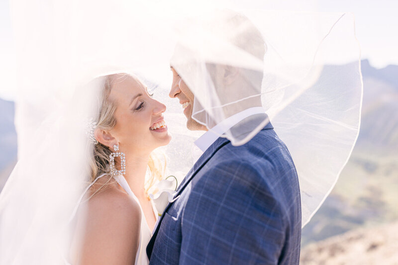 "Capture the magical moment of a bride and groom looking at each other on top of a mountain during their helicopter wedding. A breathtaking and unique celebration amidst the stunning backdrop of the Canadian Rockies."