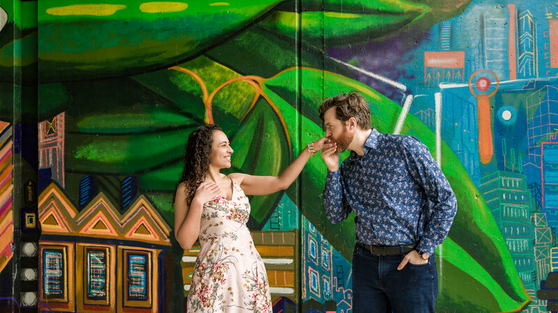 Couple standing against a bold and colorful mural in Philadelphia, perfectly showcasing local flair during their engagement session.