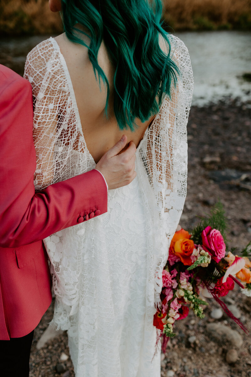 bride and groom holding hands walking through a field