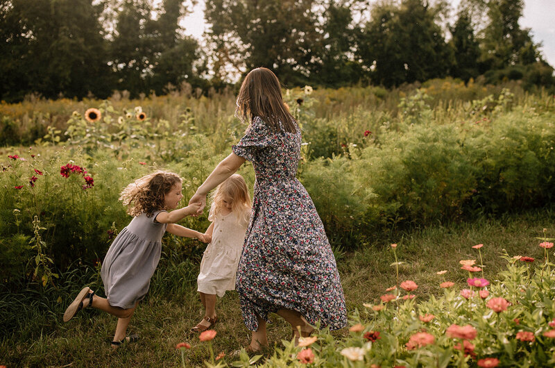 Mom and daughter dancing in flower field