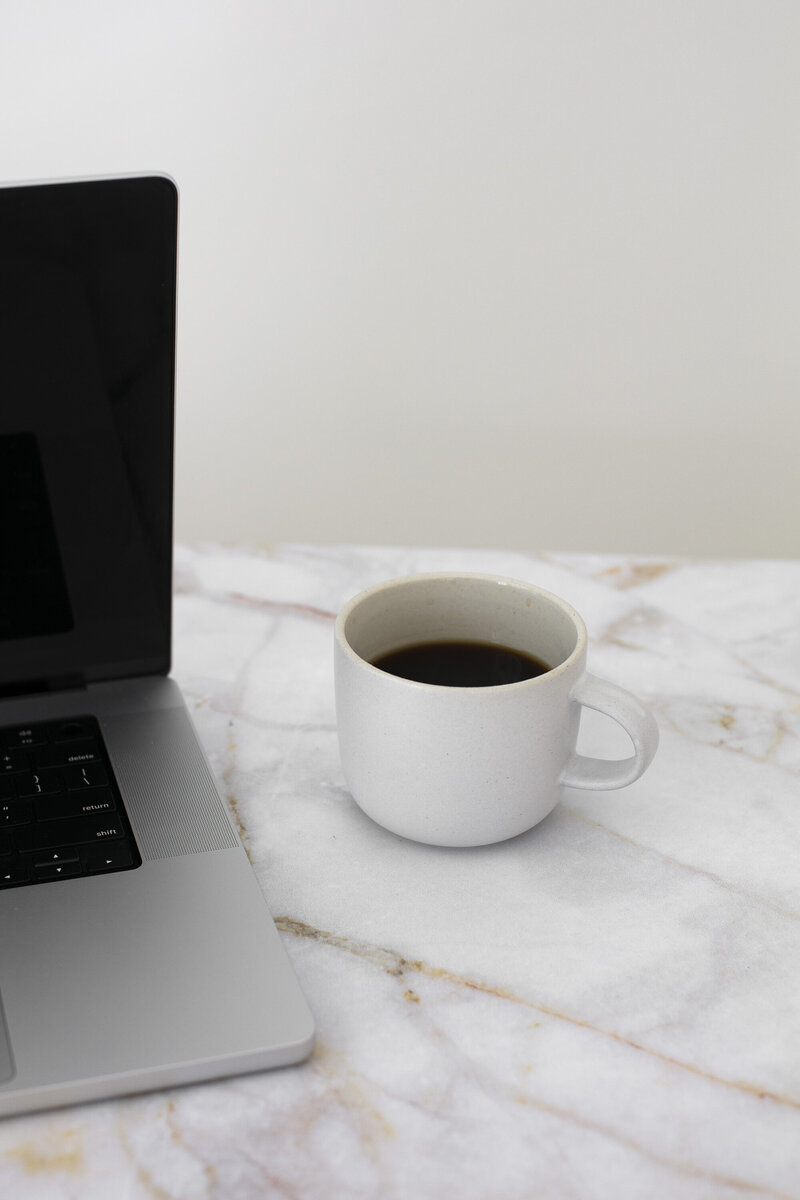 Laptop & Full Coffee Mug on Marble Table