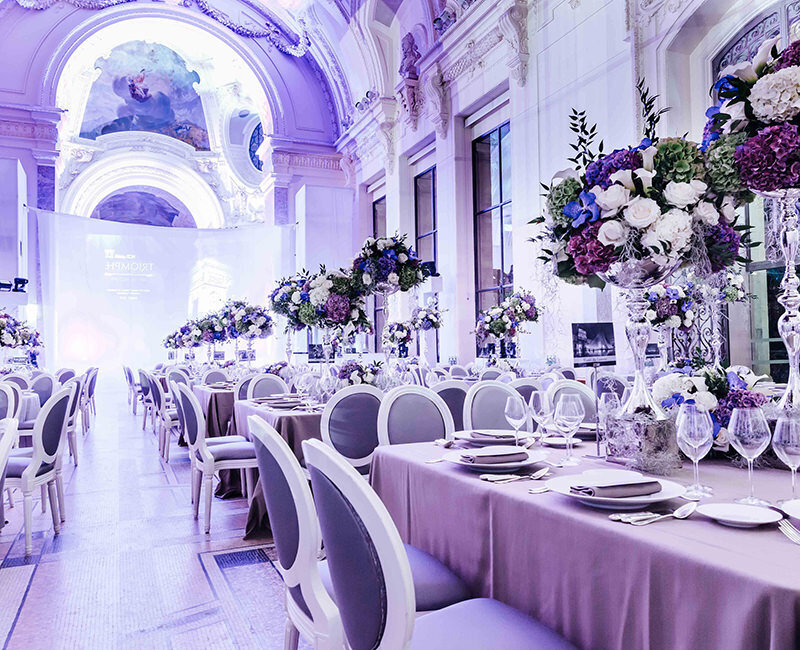 Large tables with purple tablecloths and floral centerpieces