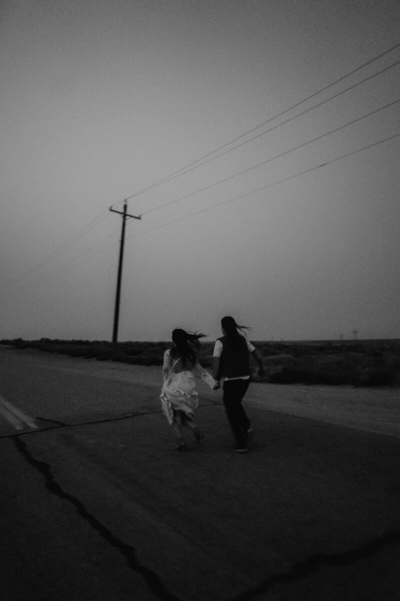 idaho elopement photography photo of brides running along the streets of the snake river during their elopement