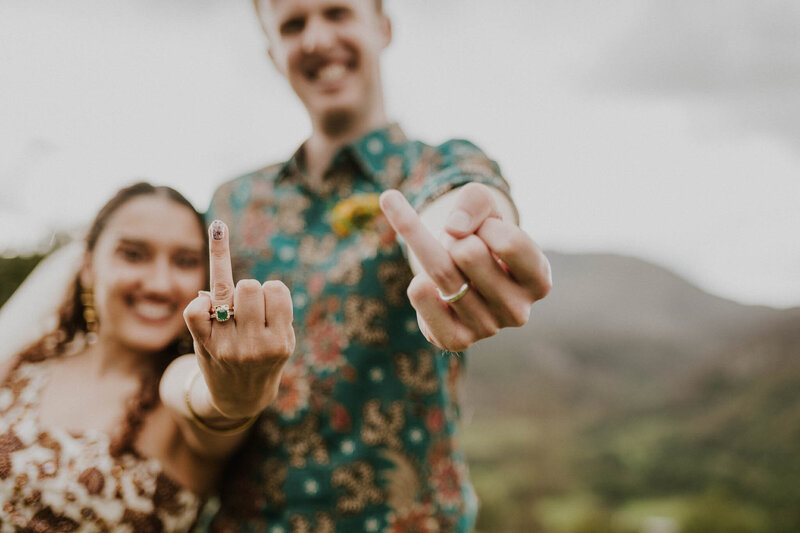 bride and groom with their wedding fingers up