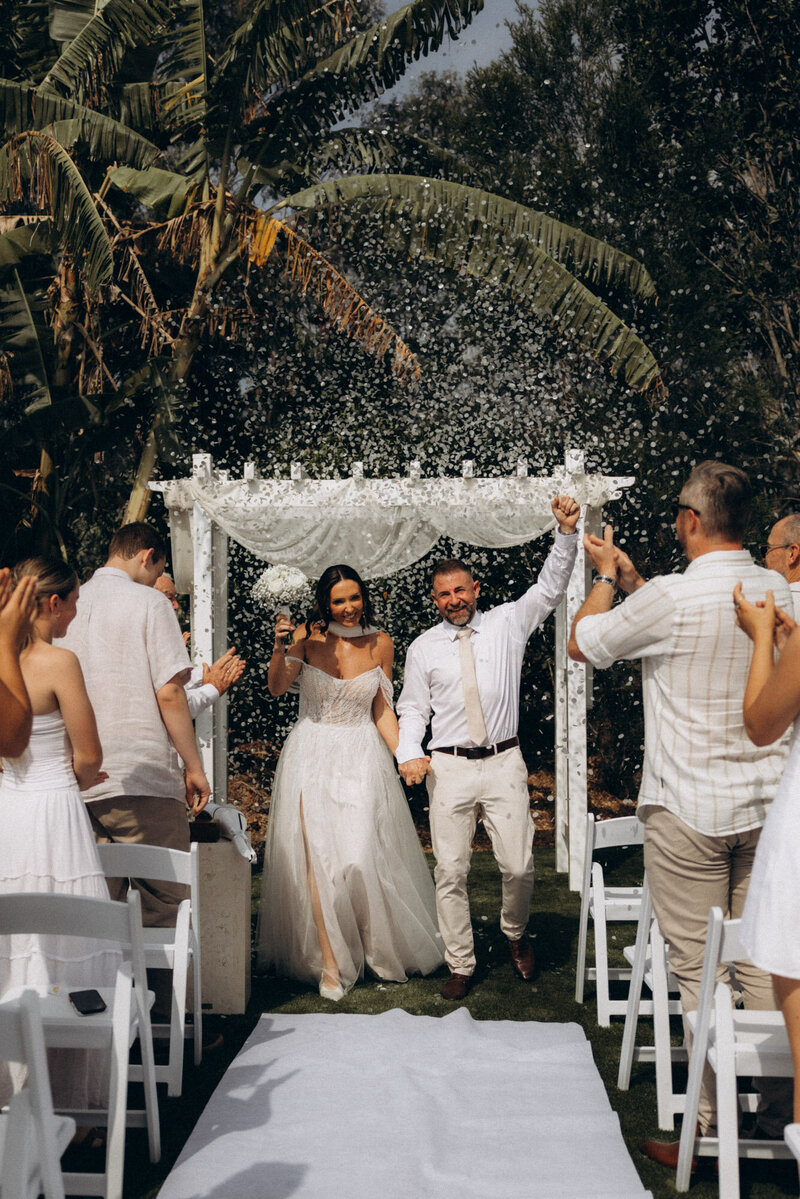 Luxury skincare brand photography featuring two women on the beach, holding facial serums in golden sunlight. Natural and storytelling brand photography for beauty and wellness brands, captured on the Sunshine Coast.