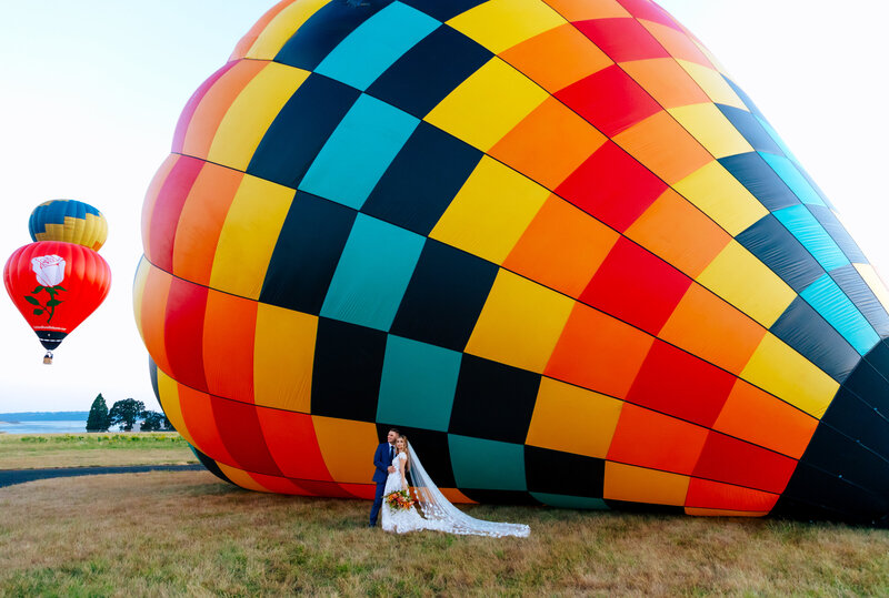 photo of a hot air balloon with a couple getting married in front of it Oregon Coast Elopement and Wedding Photographer