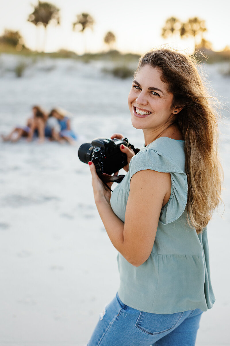 Family photographer from Erin Elyse Photography smiles before taking photo of children at Atlantic Beach, FL.