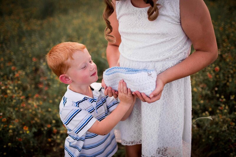 mother and son hold crochet cradle for stillborn baby boy in heaven