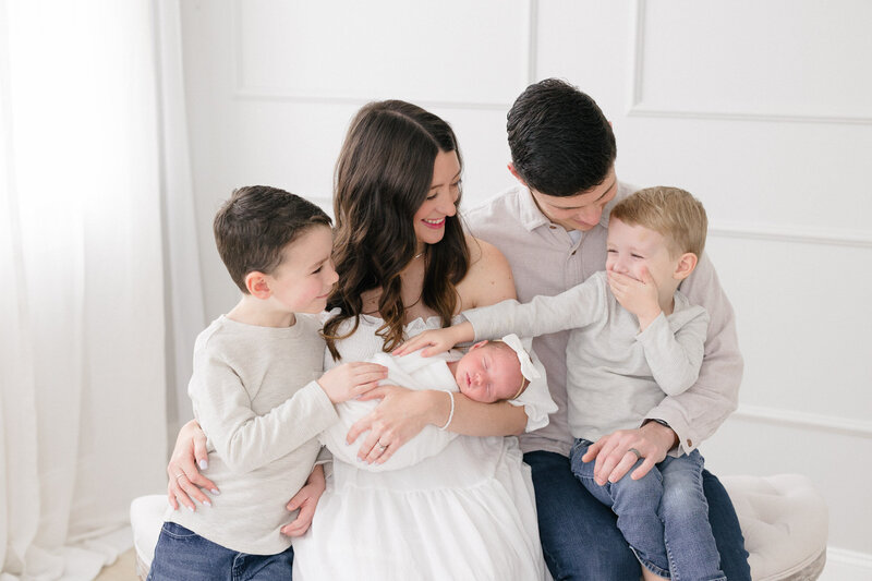 Family of five smiling during their newborn session in a northern kentucky newborn photography studio