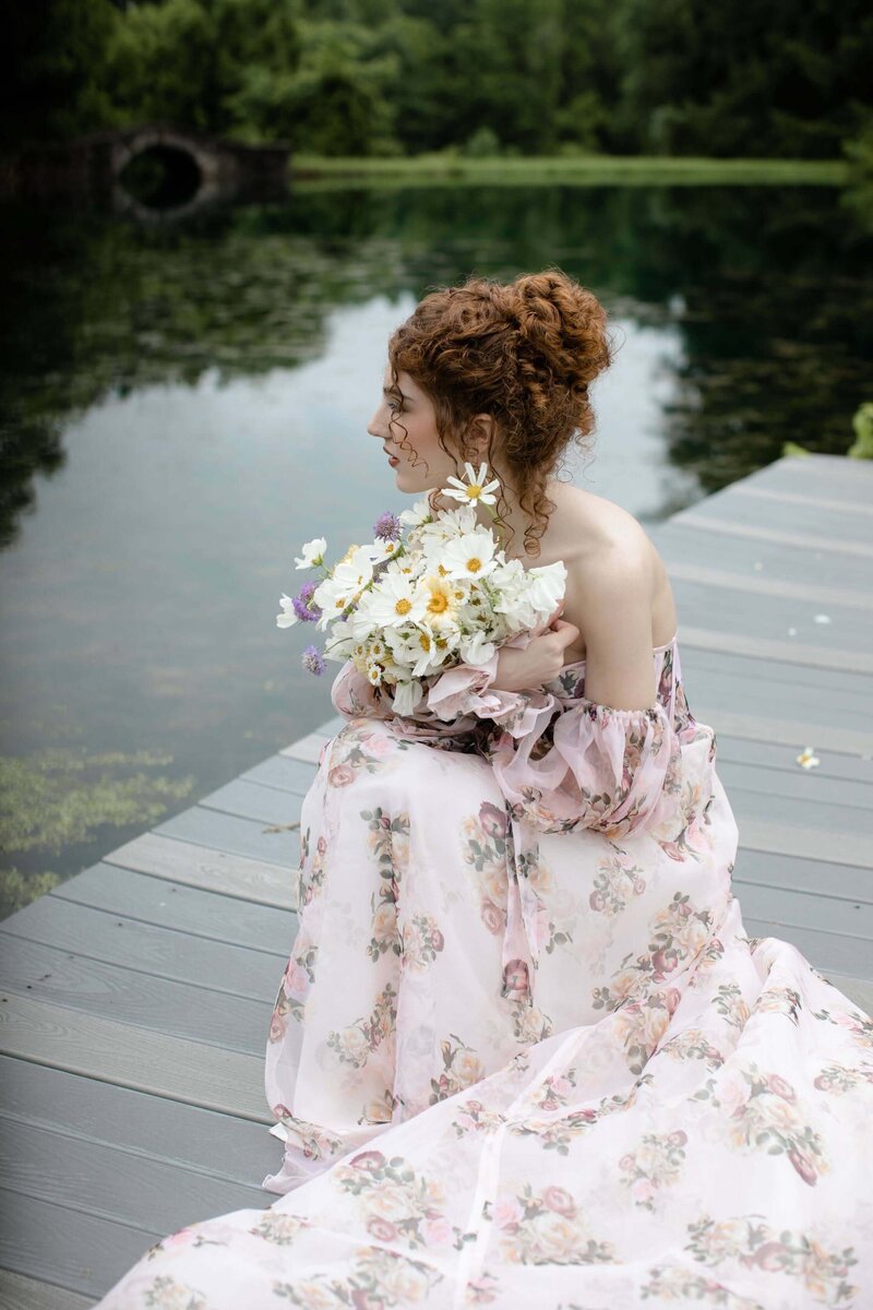 Bride holding a bouquet with a curly updo and soft ringlets falling around her face — whimsical, romantic bridal hair styled by Klover Beauty in Maryland.