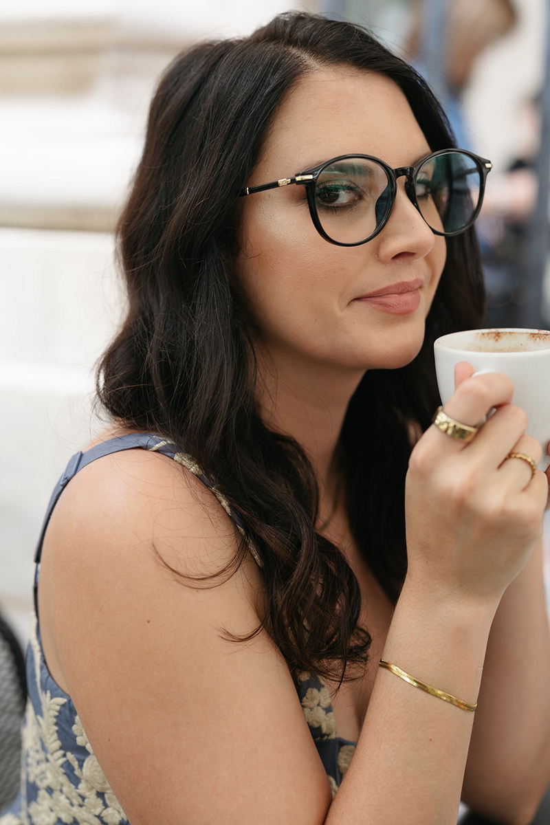 A photo of the La Perle Retreats Founder, Raquel Bickford, sipping a latte at a cafe in France in 2023