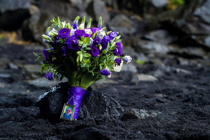 Bridal bouquet placed in the sand on a black sand beach in Iceland, adding a delicate touch to the dramatic landscape.