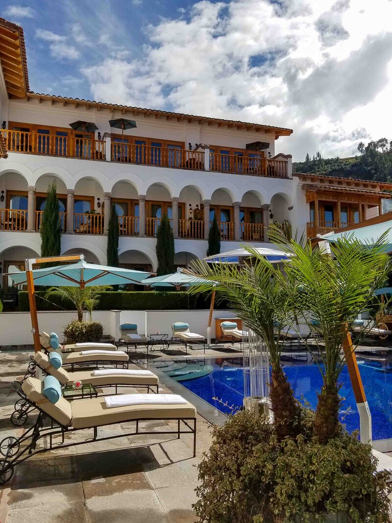 Sunlit poolside loungers with plush cushions and umbrellas at Belmond Palacio Nazarenas, Cusco, Peru, a top choice for luxury hotel stays in the Andes ©Stephanie Dosch | theViatrix Luxury Travel