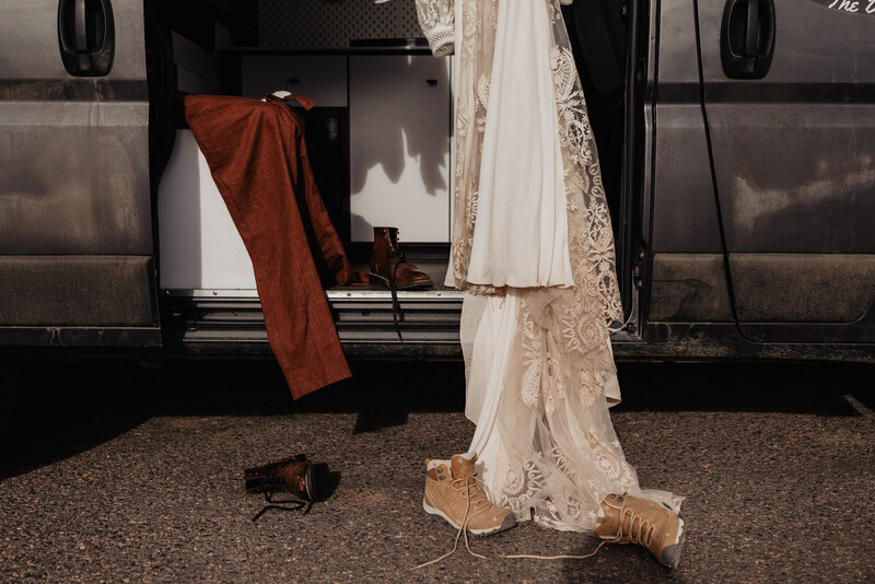 Wedding dress and suit in camper van dirty after adventure elopement