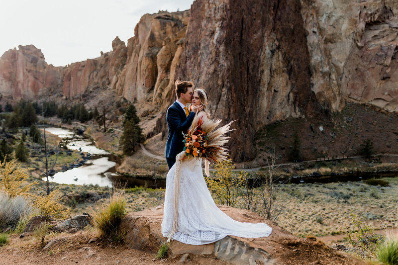bride and groom near rocks